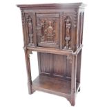 A 19thC oak carved gothic cabinet, the rectangular top above a carved and frieze door, with two fi