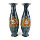 A near pair of Royal Doulton stoneware vases, each with a flared rim, the body with raised bead work