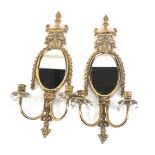 A pair of brass gilt oval wall mirror, with oval mirror plate and two candlesticks with crystal