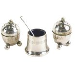 A silver plated three piece cruet set, comprising two pepper pots, on bun feet, 6cm high, and a plat