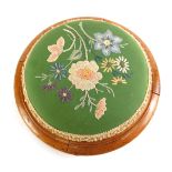 A Victorian mahogany footstool, the padded seat embroidered with flowers, 31cm diameter.
