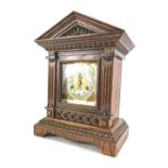 A late 19th/early 20thC German mantel clock, in an architectural carved oak case, the brass dial wit