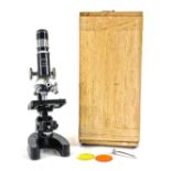 A Janik zoom 50X-900X student's microscope, in wooden case.