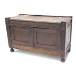 An oak side cabinet, with carved an banding and two doors, on bun feet, 51cm high, 99cm wide, 43cm d