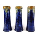 Three Royal Doulton stoneware vases, each decorated with flowers, stylised leaves in Art Nouveau sty