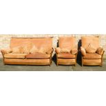 An Ercol elm sofa suite, comprising three seater sofa, and two single arm chairs, each with terracot