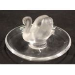 A Lalique glass pin dish, with central frosted swan, and fluted base, 9cm wide.