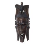 Tribal art. A carved wall mask, with eagle crest, 79cm high, 35cm wide.