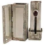 A Continental white metal lipstick holder, the outer case with floral scroll detail, with a red cabo