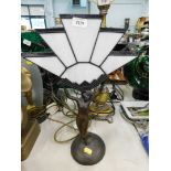 An Art Deco style gilded table lamp, the star shaped white shade, with semi nude female stand.