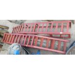 A pair of metal car ramps, painted in red.