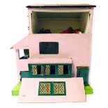 A mid century doll's house, painted in pink, with dark green woodwork, together with some figures an