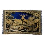 A Eurasian blue ground rug, decorated with a stag in a landscape, 120cm x 185cm.