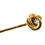 A Victorian diamond set stick pin, in a scrolling mount, yellow metal, approximately 1/16ct, boxed,