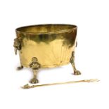 An oval brass planter, with lion's head and ring handles, raised on four paw feet, 46cm wide, togeth