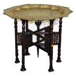 A Chinese pierced brass shaped tray top table, with hardwood folding six leg stand, 53cm high, 82cm