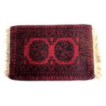 An Afghan Nahzat red ground prayer rug, decorated with two central medallions, within repeating geom