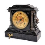 A late 19thC American ebonised metal mantel clock, circular brass dial with chapter ring bearing Ara