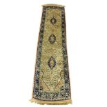 A Persian Naim runner, decorated with three medallions and floral motifs, within repeating floral an