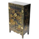 An early 20thC Chinese black and gilt lacquer cabinet on stand, decorated to the doors with a landsc