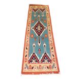 A Turkish Kilim blue ground runner, with a central geometric medallion, and four half medallions, wi