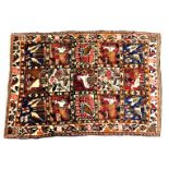 A Bakhtiari rug, decorated with fifteen panels of animals and birds, within repeating bird, animal,