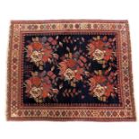 A Caucasian blue ground rug, the central field filled with five bold foliate motifs, within repeatin