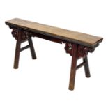A Chinese elm and red lacquered bench, with scroll carving, raised on turned legs, 120cm wide.