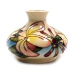 A Moorcroft pottery Frangipani pattern pottery vase, decorated on a white ground, of compressed balu