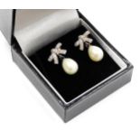 A pair of The Pearl Company cultured baroque pearl earrings, on cz set bow suspensions.