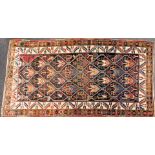 A Turkish Kilim brown ground rug, decorated with repeating tree motifs, within foliate and floral bo