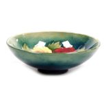 A Moorcroft pottery Hibiscus pattern bowl, green ground, impressed marks, 14cm wide.