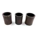 Three Chinese hardwood cylindrical brush pots, of plain design, one with a hole to the base, the tal