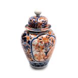 A Chinese Imari porcelain vase and cover, decorated with reserves of flowers, within a floral ground