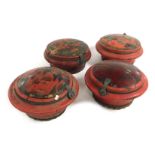 Four Chinese red lacquered wooden circular food containers, with decorated lids.