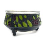 A Russian enamel salt, with a clear glass liner, decorated with a band of berries and leaves, on whi