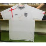 An England signed 2005-07 home football shirt, signed, framed and glazed, 116cm x 128cm.