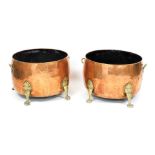 A pair of copper and brass log buckets, with twin brass handles, raised on four cabriole legs and pa