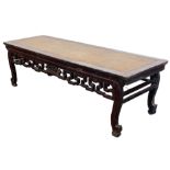 A Chinese hardwood low side table, with raffia top, carved frieze, 54cm high, 178cm wide, 58cm deep.