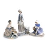 A Lladro porcelain figure of a kneeling woman and calf, further figure group of a lady with a duck a