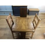 An extending oak kitchen table and three various chairs. Note: VAT is payable on the hammer price o