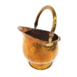 A late 19thC brass helmet shaped coal scuttle, with swing handle, 36cm high.