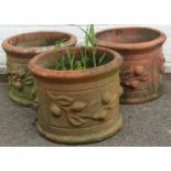 A set of three terracotta circular planters, each with tulip design, 30cm high, 40cm diameter. (3)