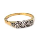 An 18ct gold diamond five stone dress ring, the five stones in platinum setting, on a yellow metal b