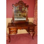 A 20thC mahogany dressing table, the mirror with a leaf and shell carved top, the base with a moulde