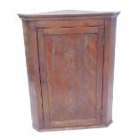 A 19thC oak hanging corner cabinet, the top with moulded edge above a paneled door, 102cm high, 74cm