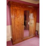 A Victorian mahogany triple wardrobe, the top with a moulded edge above three doors, the central doo