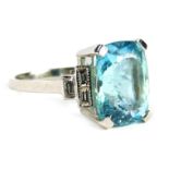 An Art Deco aquamarine and diamond cluster ring, with central cushion cut aquamarine in four claw se