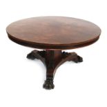 A William IV rosewood circular breakfast table, the tilt top above a triform base, with reeded and s