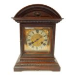 An early 20thC oak cased mantel clock, the square brass dial bearing Roman numerals within a silvere